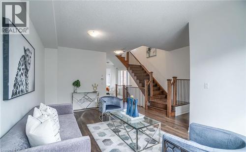 Open concept living space featuring wood-finish flooring, a contemporary staircase with dark wood railings, and recessed ceiling lighting - 14 Faye Street, Brampton, ON - Indoor