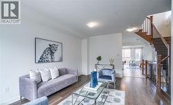 Main living area featuring dark wood-finish flooring, white walls, and recessed lighting - 