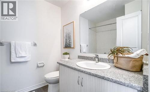 Bathroom featuring a single vanity with an integrated sink, stone-finish countertop, and wood-grain cabinetry - 14 Faye Street, Brampton, ON - Indoor Photo Showing Bathroom
