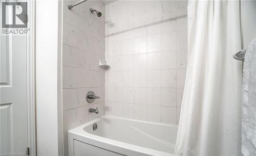 Bathtub and shower combination featuring white tiled surround - 14 Faye Street, Brampton, ON - Indoor Photo Showing Bathroom