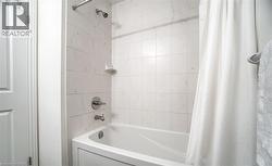 Bathtub and shower combination featuring white tiled surround - 