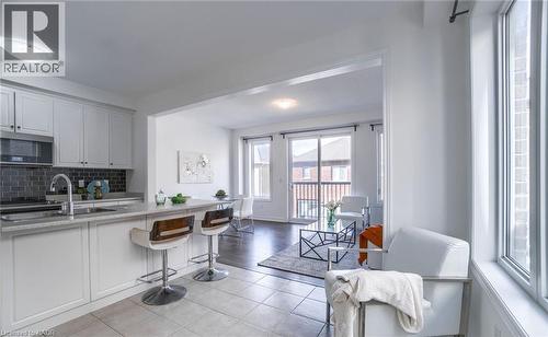 Kitchen featuring white cabinetry, stainless steel appliances, a dark tile backsplash, and a breakfast bar with seating - 14 Faye Street, Brampton, ON - Indoor Photo Showing Kitchen