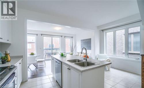 Open-concept kitchen featuring white cabinetry, a double basin sink, and tile flooring - 14 Faye Street, Brampton, ON - Indoor Photo Showing Kitchen With Double Sink With Upgraded Kitchen