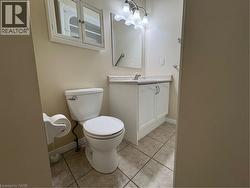 Bathroom featuring a white vanity with a light-toned countertop, a wall-mounted mirror, and a multi-bulb light fixture - 