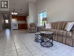 Spacious open-concept living area featuring light-toned tile flooring throughout - 