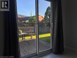 Sliding glass door opening to an outdoor wood-finish deck - 