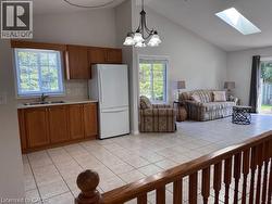 Open-concept living space with vaulted ceilings, a skylight, and durable tile flooring throughout - 