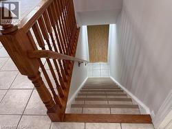Staircase featuring wood-finish banister, newel post, and handrail - 
