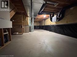 Unfinished basement with concrete flooring, exposed wood joists, utility ductwork, and insulation - 