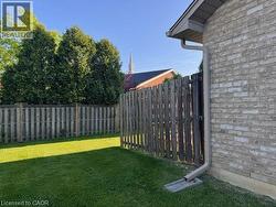 Expansive lawn area enclosed by a wood picket fence and mature evergreen trees - 