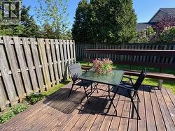Expansive wood deck featuring a built-in bench, surrounded by a privacy fence, and backed by mature trees - 