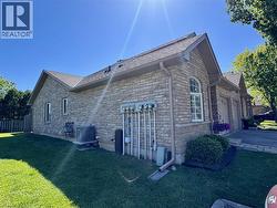 Brick exterior with an arched window, a gabled roof, and a mature shrub - 