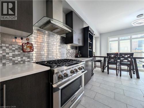 Modern kitchen featuring stainless steel appliances, dark wood-finish cabinetry, and light-toned countertops - 37 Mull Avenue, Caledonia, ON - Indoor Photo Showing Kitchen With Upgraded Kitchen