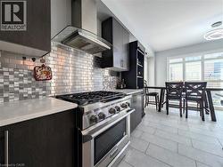 Modern kitchen featuring stainless steel appliances, dark wood-finish cabinetry, and light-toned countertops - 