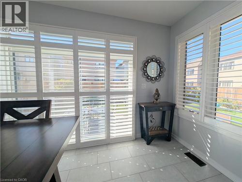 Light gray tiled flooring, white plantation shutters, and a sliding glass door - 37 Mull Avenue, Caledonia, ON - Indoor Photo Showing Other Room