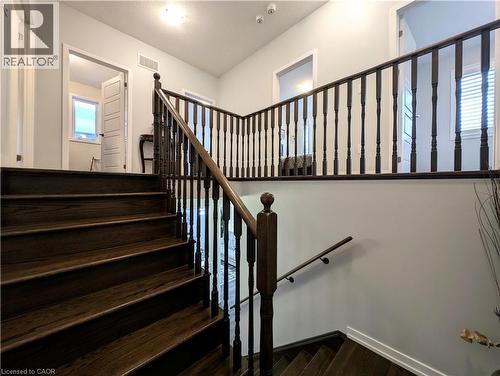 Dark wood-finish stairs with matching balusters and handrails - 37 Mull Avenue, Caledonia, ON - Indoor Photo Showing Other Room