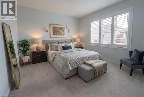 Soft gray wall color with recessed lighting, plush carpet flooring, and a large window with white plantation shutters - 37 Mull Avenue, Caledonia, ON - Indoor Photo Showing Bedroom