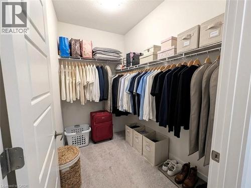 Walk-in closet featuring light grey carpeting, white wire shelving, and extensive hanging rods - 37 Mull Avenue, Caledonia, ON - Indoor With Storage