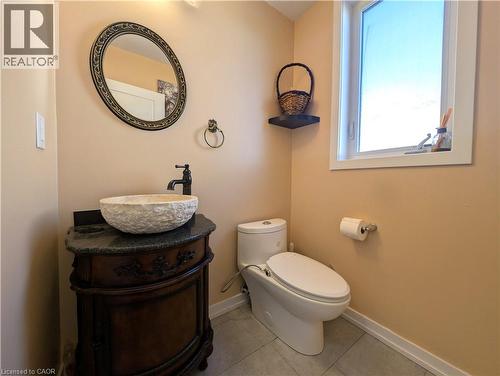 Wood-finish vanity with a vessel sink and dark stone countertop - 37 Mull Avenue, Caledonia, ON - Indoor Photo Showing Bathroom