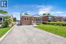 Brick exterior ranch-style home featuring a paved driveway, front steps with white railings, and a manicured front lawn - 450 Highland Road E, Kitchener, ON 