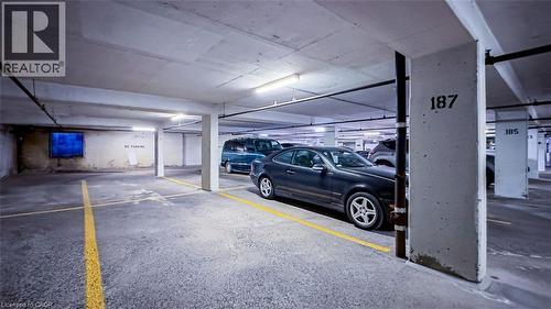 Underground parking garage featuring concrete pillars and ceiling, bright overhead lighting, and clearly marked designated parking space. - 40 Harrisford Street Unit# 802, Hamilton, ON 