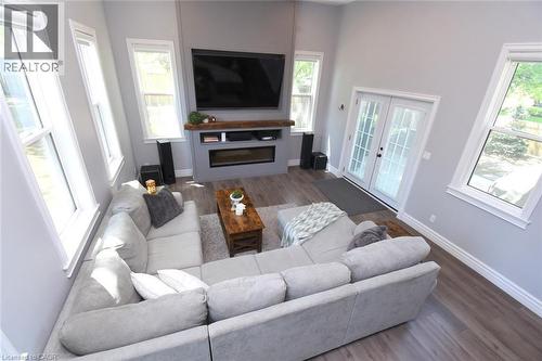 Spacious living area featuring a 12ft vaulted ceiling, contemporary fireplace with a wood mantle, and multiple windows providing natural light - 89 Lynden Road, Lynden, ON - Indoor Photo Showing Living Room