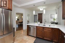 Kitchen with rich wood cabinetry, quartz countertops and stainless steel appliances - 