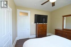 Room featuring wood-finish flooring, neutral wall tones, and white trim work - 