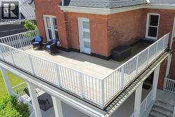 Expansive upper-level deck featuring white railing, white exterior door and white railings - 