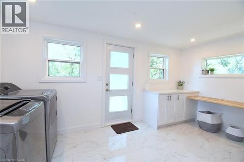 Bright utility room featuring white cabinetry, a light wood-finish folding counter, and recessed lighting - 89 Lynden Road, Lynden, ON 