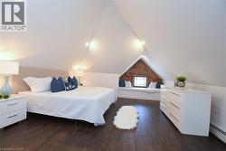 Spacious primary bedroom with a built-in window seat and exposed brick accent reading nook - 