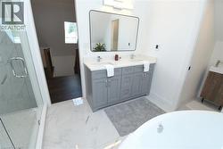 Contemporary bathroom featuring a dual vanity with light gray cabinetry, white countertops, and chrome fixtures - 