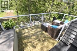 Elevated wood-plank deck featuring a clear panel railing system with white posts and handrails - 