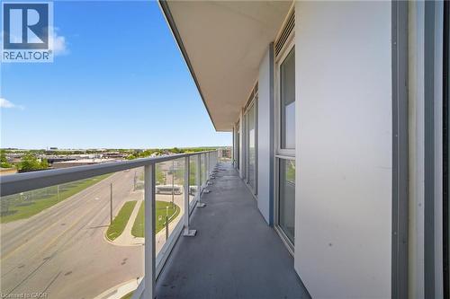 Spacious private balcony featuring a glass panel railing, concrete flooring, and multiple exterior windows - 2782 Barton Street E Unit# 516, Hamilton, ON - Outdoor With Balcony With View With Exterior