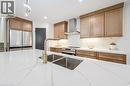 Kitchen featuring wall chimney exhaust hood, stainless steel appliances, light stone countertops, brown cabinetry, and recessed lighting - 459 Drummerhill Crescent, Waterloo, ON  - Indoor Photo Showing Kitchen With Stainless Steel Kitchen With Double Sink With Upgraded Kitchen 