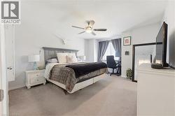 Spacious bedroom featuring light neutral wall paint and plush carpet flooring - 