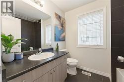 Bathroom vanity featuring an integrated sink, laminate countertop, and wood-finish cabinetry with silver hardware - 