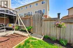 Private backyard featuring a paved patio area, an arched wooden gate, and perimeter fencing - 