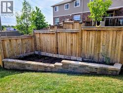 Manicured lawn with a stone-bordered raised garden bed - 