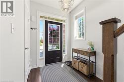 Entry foyer featuring a black paneled door with glass inserts, transom window, and sidelights - 