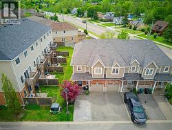 Townhome exterior with brick and siding facade, featuring gabled roofs and individual garage doors - 