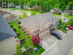 Townhome with brick and siding exterior, individual garages, and private fenced backyards - 