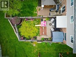Multi-level outdoor living space featuring a wood-finish deck, an adjacent stone paver patio, and a separate ground-level patio area - 