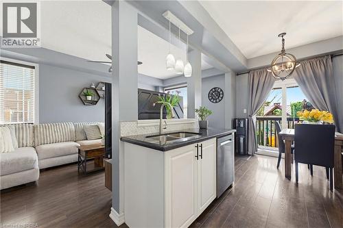 Kitchen island with dark countertop, undermount sink, and stainless steel dishwasher - 100 Chester Drive Unit# 16, Cambridge, ON - Indoor