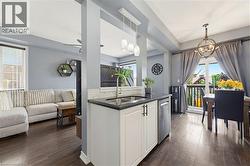 Kitchen island with dark countertop, undermount sink, and stainless steel dishwasher - 