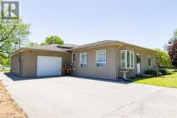 Ranch-style exterior featuring a single-car garage, bay window, and a spacious paved driveway - 