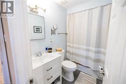 Bathroom featuring a white vanity with integrated sink, chrome faucet, and rectangular mirror - 