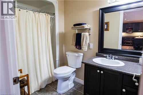 Bathroom featuring a shower/tub combination, floor-set toilet, and a vanity with a dark countertop and under-sink storage - 100 Mechanic Street W, Waterford, ON - Indoor Photo Showing Bathroom