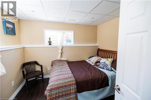 Compact room with dark wood-finish flooring, light tan walls, and white trim - 100 Mechanic Street W, Waterford, ON - Indoor Photo Showing Bedroom