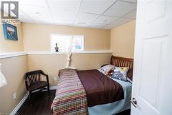 Compact room with dark wood-finish flooring, light tan walls, and white trim - 